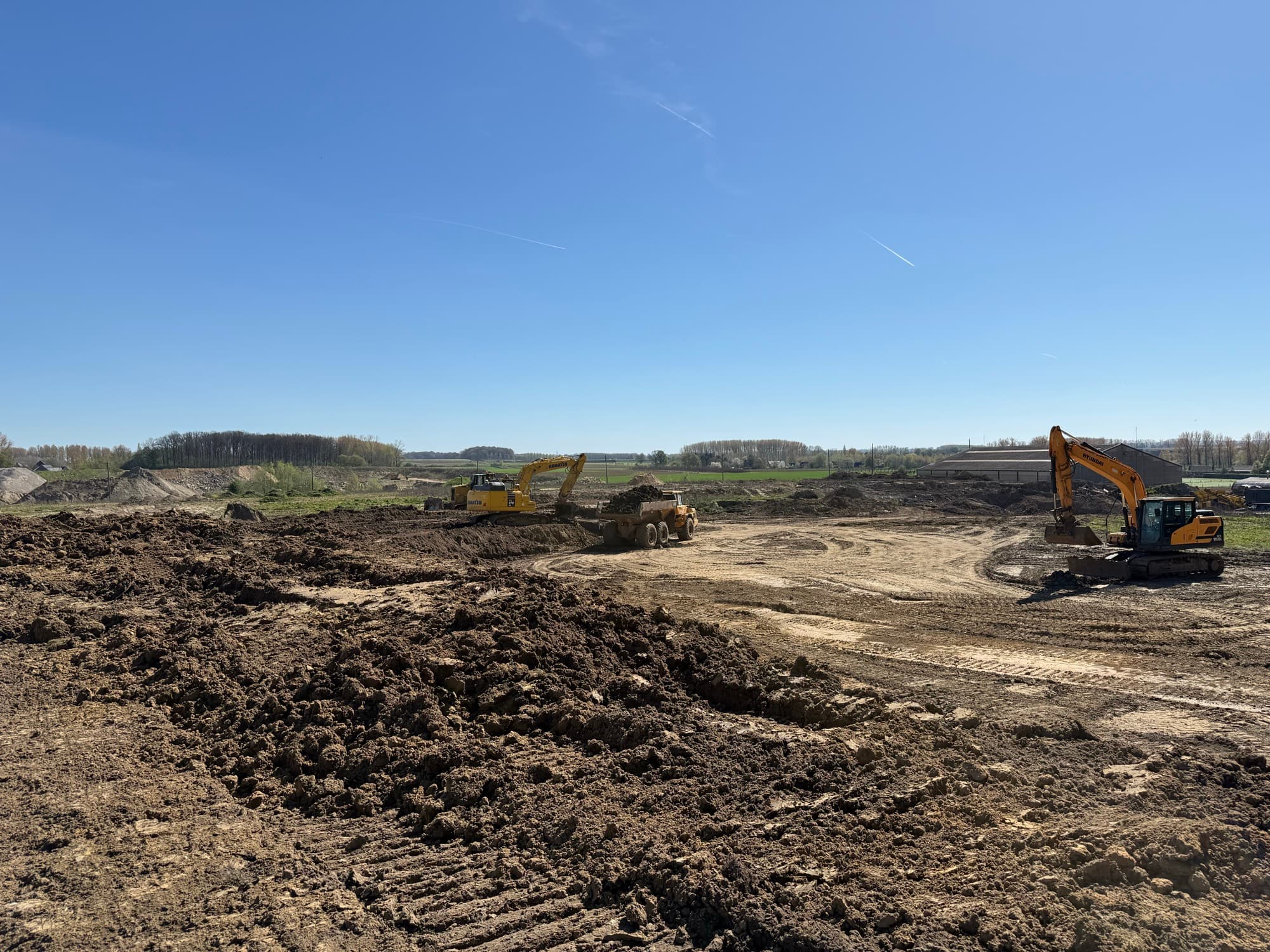 Terrein in ophoging met twee graafkranen en een dumper